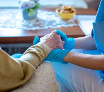 Young female doctor is holding her patient's hand, comforting her. Old lady is worried and doctor is there to take care of her every need. Old lady is in trusting hands.