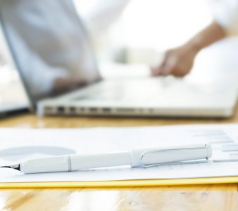 Closeup pen on analysis chart and blur working hands of businessman.