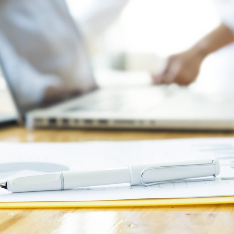 Closeup pen on analysis chart and blur working hands of businessman.